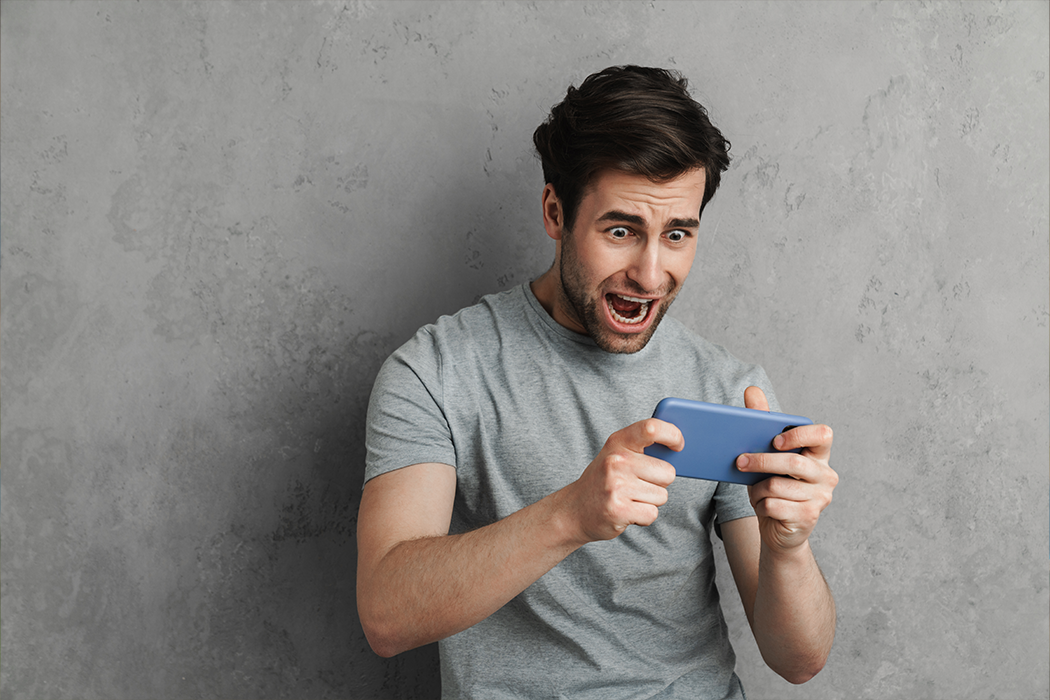 An excited man playing a game on his phone